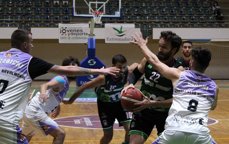 Un jugador de Electromercantil CB Plasencia es defendido por sus rivales durante un encuentro.